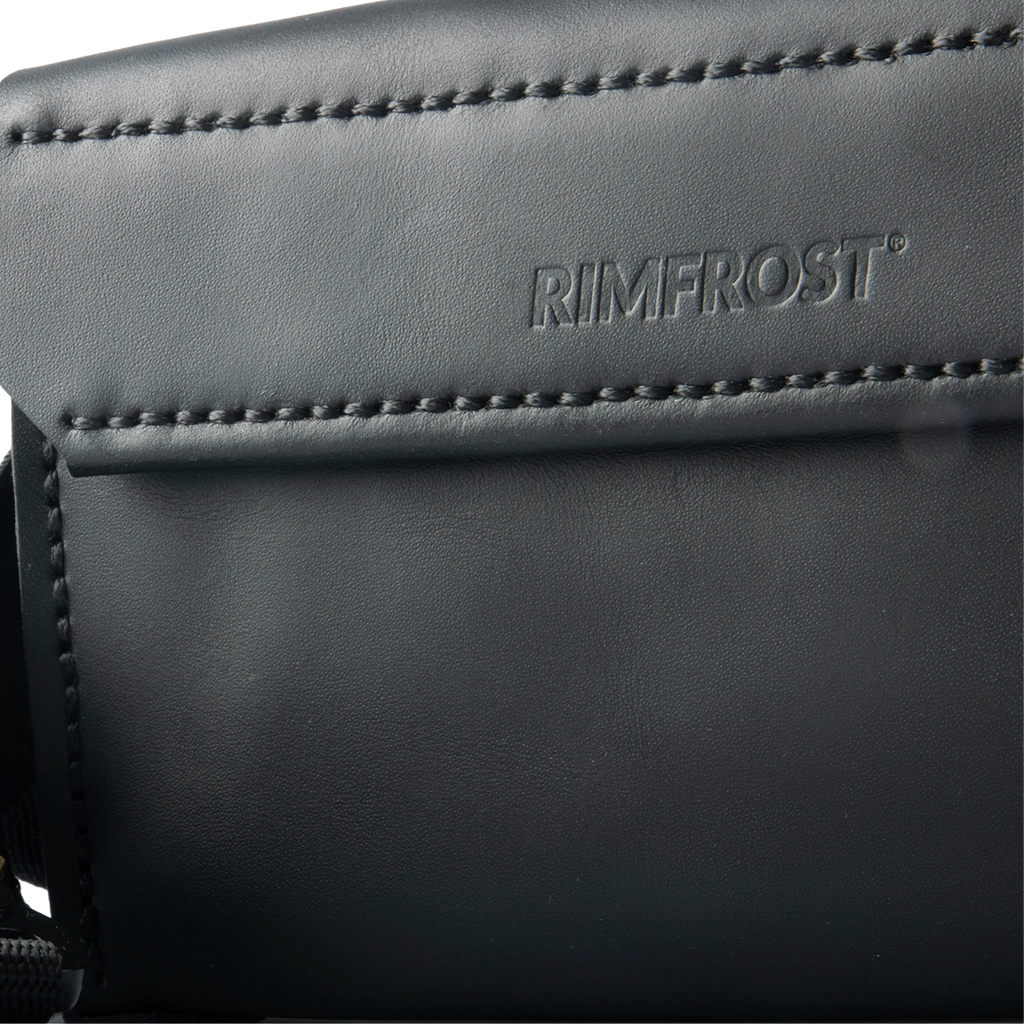 Close-up of a black leather product with 'RIMFROST' branding.