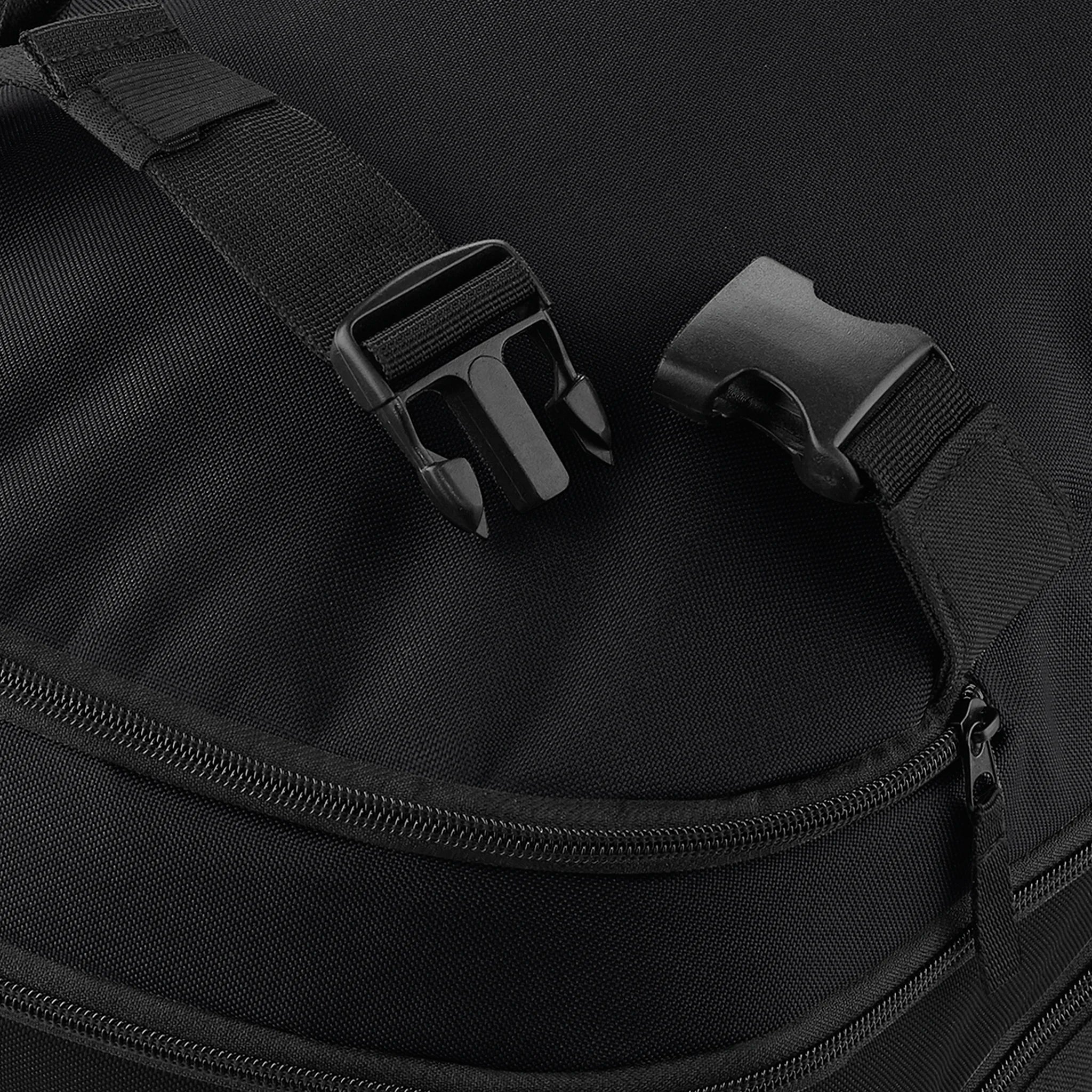 Close-up of a black bag with a strap and buckle on a dark background
